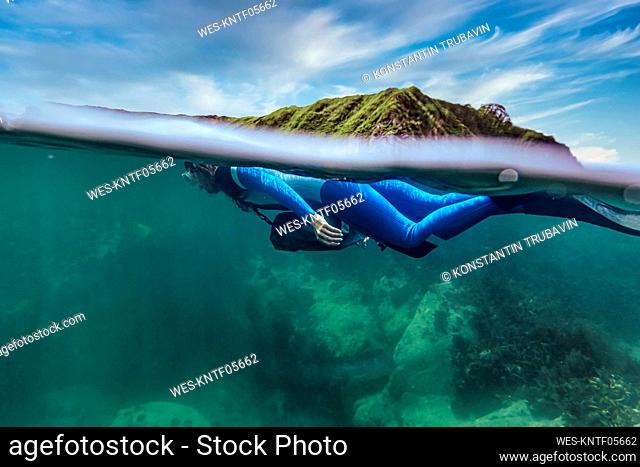 Woman in diving suit diving undersea