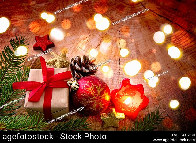Christmas gift with red ball , candle and fir branch , top view with copy space on wood. Christmas card