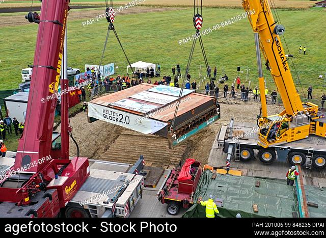 06 October 2020, Baden-Wuerttemberg, Herbertingen: Two heavy-duty cranes lift a block weighing around 80 tons and measuring eight by six metres so that it can...