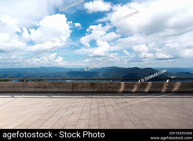 empty marble floor and green hill in blue cloud sky