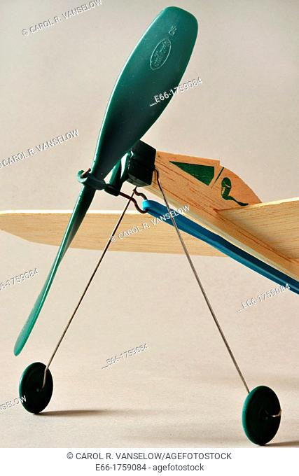 balsawood toy wind-up plane with green propellor and blue rubberband