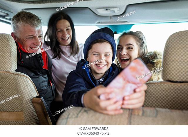 Happy family with smart phone in motor home