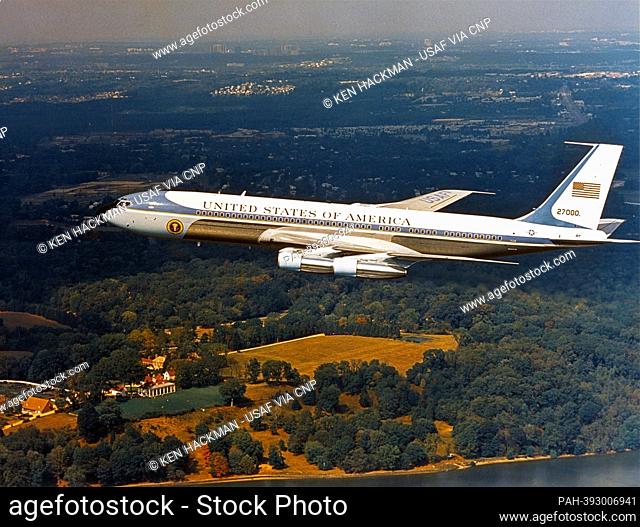 High angle side view of Air Force One, tail number 27000, a VC137 a modified version of the Boeing 707 353B, in flight over the home of US President George...