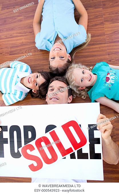 Happy family lying on floor after buying a new house