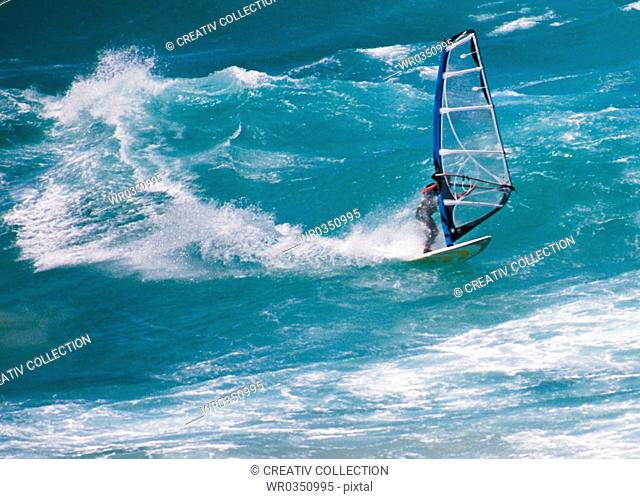 windsurfer surfing on big turquoise waves