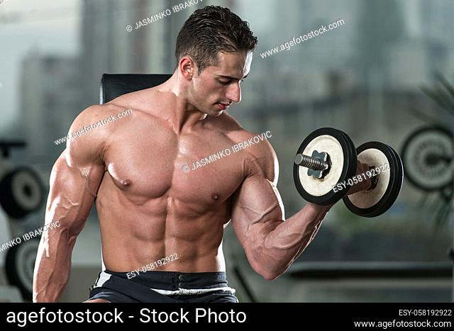 Young Man Working Out Biceps - Dumbbell Concentration Curls