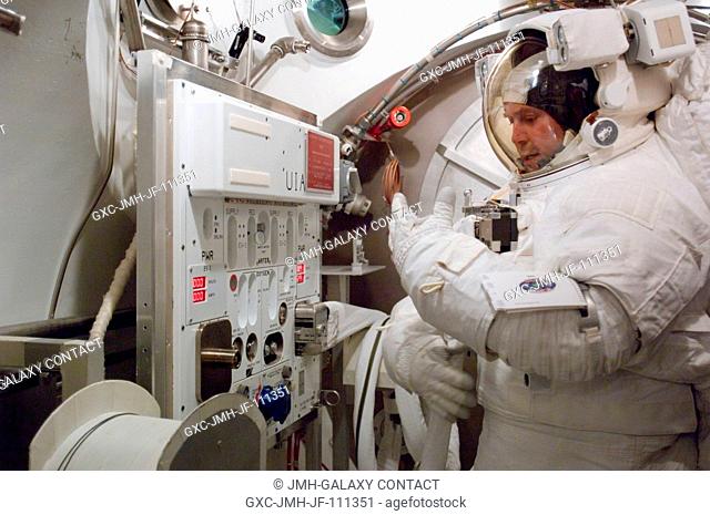 Astronaut Michael J. Foreman, STS-123 mission specialist, participates in an Extravehicular Mobility Unit (EMU) spacesuit fit check in the Space Station Airlock...