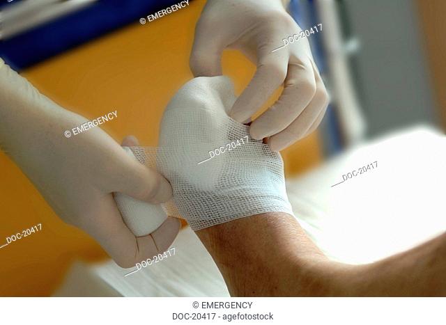 Hands in protective gloves applying a bandage at the foot of a patient - diabetes - grub therapy