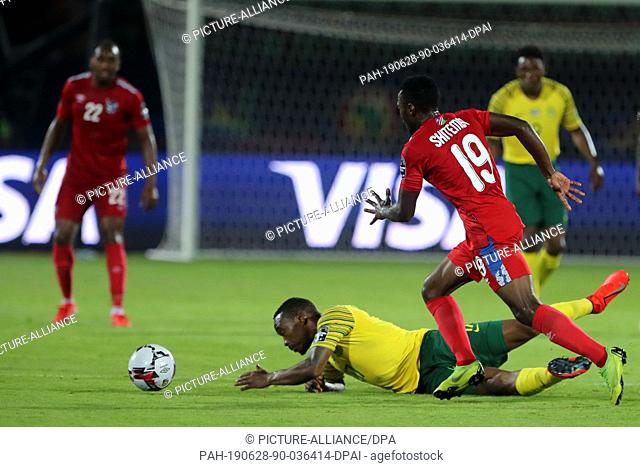 28 June 2019, Egypt, Cairo: South Africa's Sibusiso Vilakazi (C) and Namibia's Petrus Shitembi (R) vie for the ball during the 2019 Africa Cup of Nations Group...