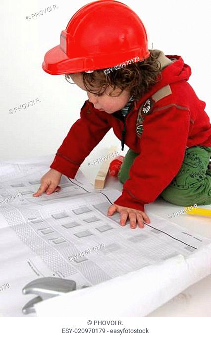 Little boy builder reading newspaper