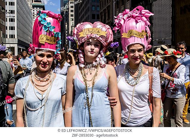 New York, NY - April 16, 2017. Three women in Marie Antoinette-style headwear, all bearing the label ""Let them eat cake