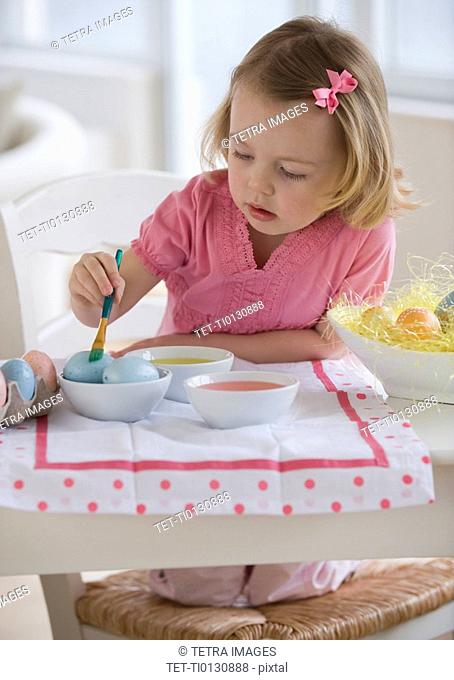 Young girl decorating eggs