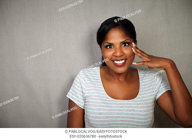 Smiling african woman in grey shirt looking at the camera - copy space
