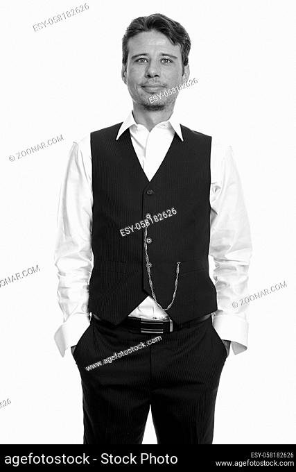 Studio shot of handsome businessman with beard stubble isolated against white background in black and white