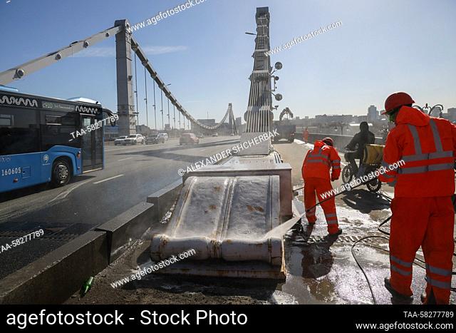 RUSSIA, MOSCOW - APRIL 7, 2023: Workers clean the surface of Krymsky Bridge in spring. Alexander Shcherbak/TASS