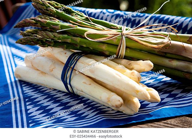 white and green asparagus on a wooden board with bavarian flag