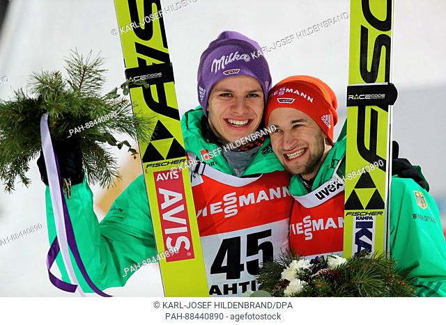 Andreas Wellinger (l) from Germany and Markus Eisenbichler (r) from Germany celebrate their podium finishes at the flower ceremony; Wellinger placed second