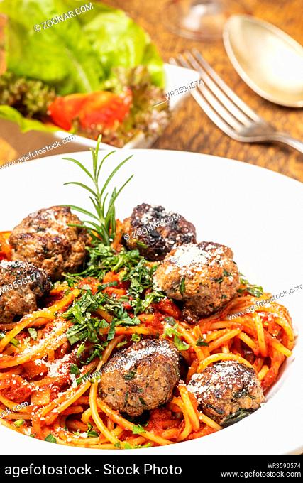 spaghetti with meat balls on dark wood