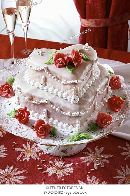 Festive two-tiered heart-shaped cake with marzipan roses