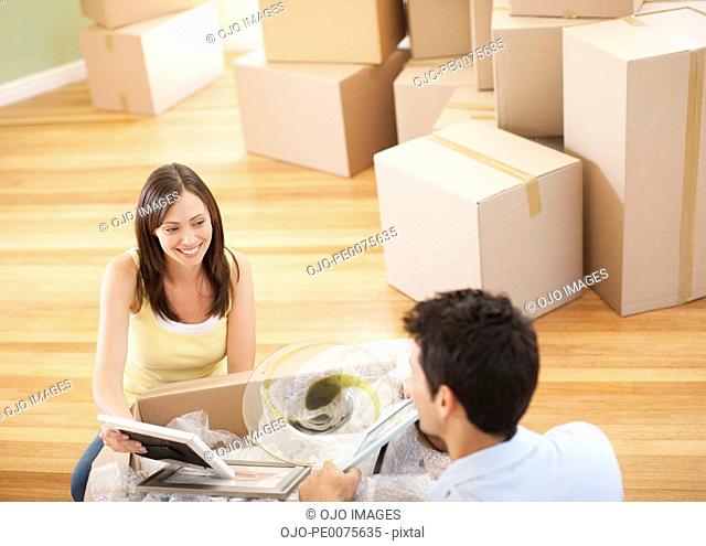 Couple unpacking pictures in new house