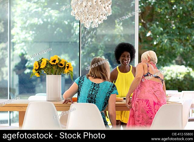 Happy senior women friends enjoying lunch at dining table