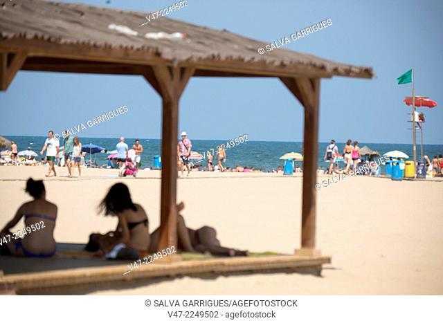 The swimmers are protected from the harsh summer sun in the shadow of tourist information booths from the beach of La Malvarrosa, Valencia, Spain, Europe