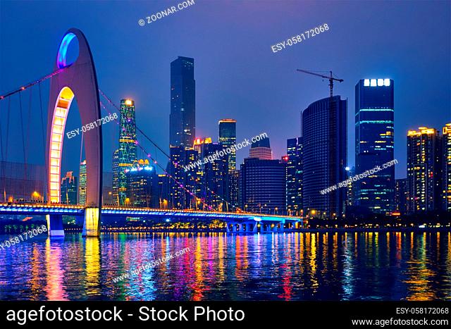 Guangzhou cityscape skyline over the Pearl River with Liede Bridge illuminated in the evening. Guangzhou, China