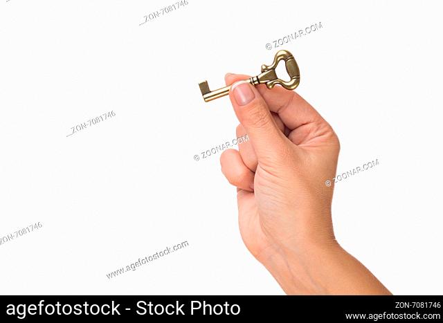 Golden key to treasures. Hand hold old key isolated on white