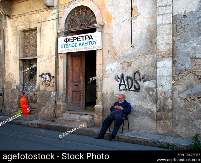 NICOSIA, CYPRUS - March 17, 2018: A coffin maker resting outside his workshop in an old crumbling building in the old town of Nicosia cyprus