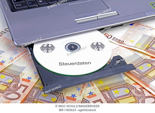 CD labelled Steuerdaten, German for tax data in a computer drive, 50 euro notes, symbolic image for illegal trade with tax data, breach of data protection