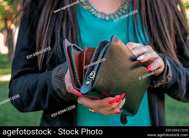 Girl looking into small fashion handbag