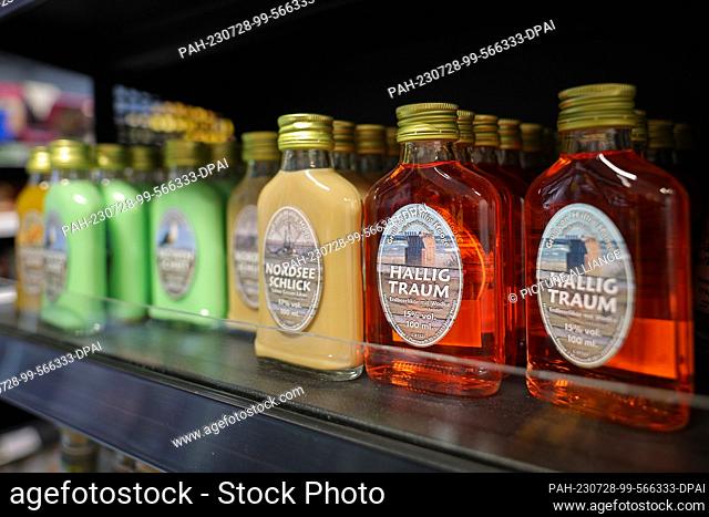 PRODUCTION - 10 July 2023, Schleswig-Holstein, Hooge: Small bottles of Hallig spirits stand on a shelf in the store of Hallig merchant Jerome Marschke on the...