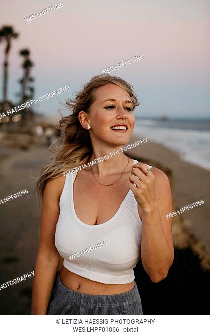 Happy young woman on the beach, Huntington Beach, California, USA
