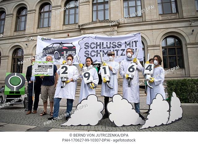 Eight activists of the Association for the Environment and Nature Protection Germany (BUND) hand over a petition titled 'Schluss mit schmutzig!' ('End the dirt