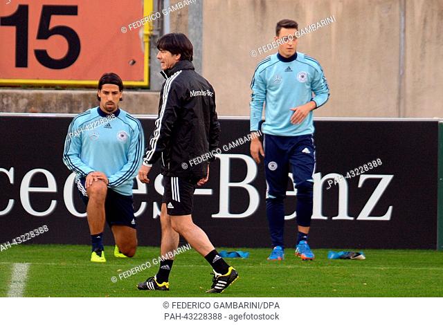 Germany's head coach Joachim Loew (M) walks past Sami Khedira (back-L) and Mesut Oezil during the training session of the German national soccer team in...