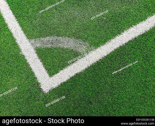 A corner arc marking on green grass pitch