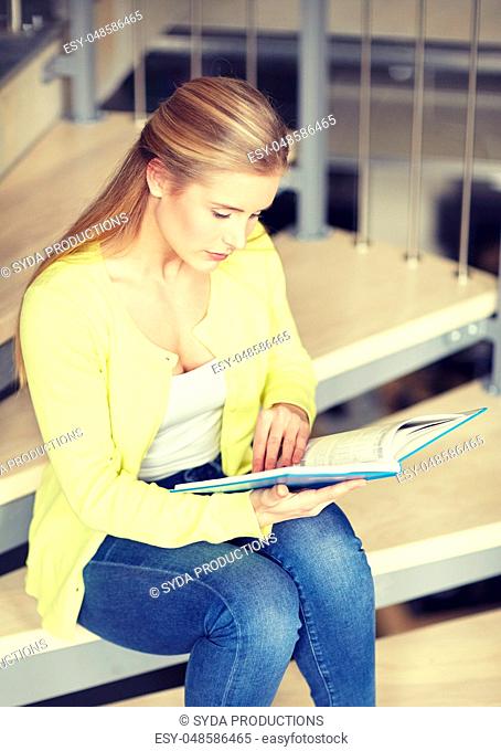 high school student girl reading book on stairs
