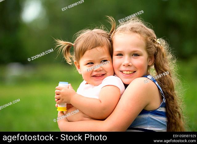 Happy little sisters - portrait in park - smiling children