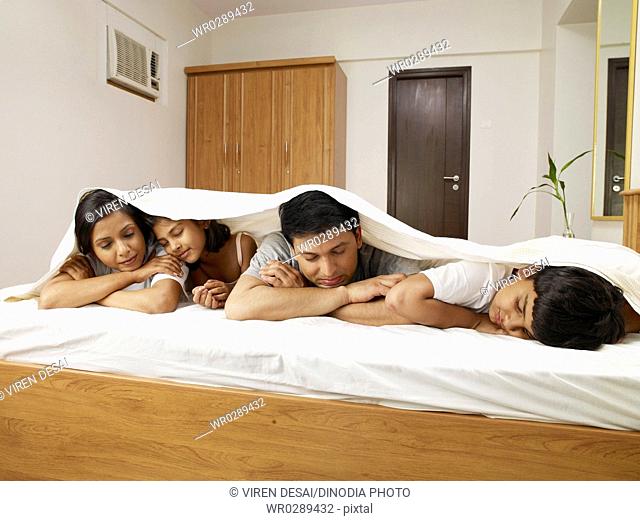 Parents with children under bed sheet sleeping on bed in bedroom MR702R, MR702S, MR702T, MR702U