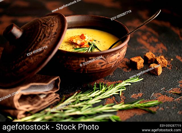 Fish cream soup with Salmon, cheese, Potatoes and herbs in in brown ceramic Soup Bowl. Dark food photography