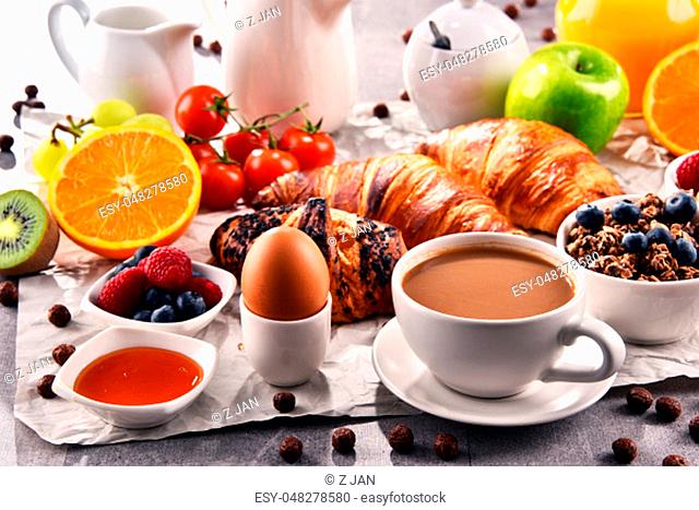 Breakfast served with coffee, orange juice, croissants, egg, cereals and fruits. Balanced diet