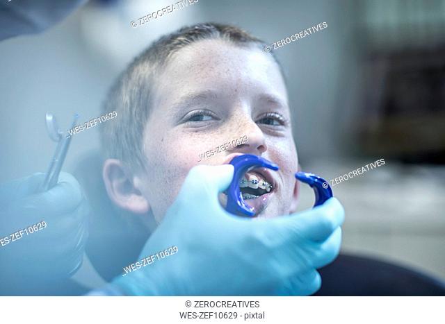 Boy in dental surgery receiving orthodontic treatment