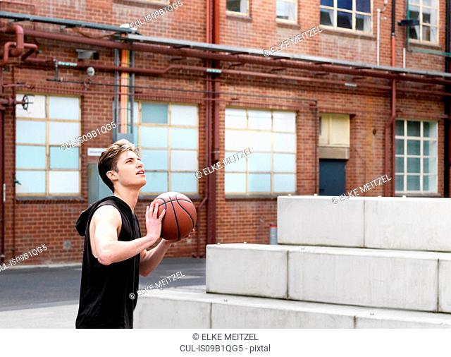 Young man playing basketball in outdoor court