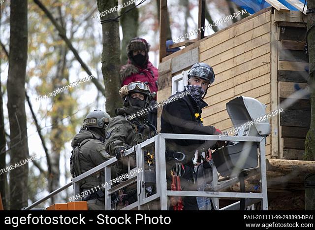 11 November 2020, Hessen, Dannenrod: With a hoisting crane the police tries to get the squatters out of their tree house