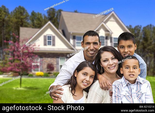 Happy hispanic family portrait in front of beautiful house