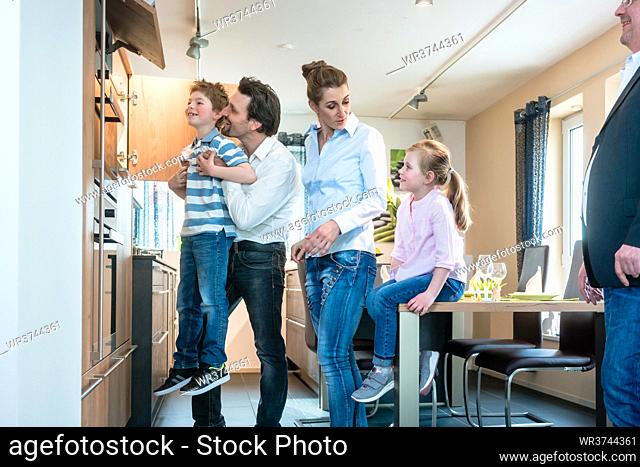 Happy family looking at a new kitchen in the showroom