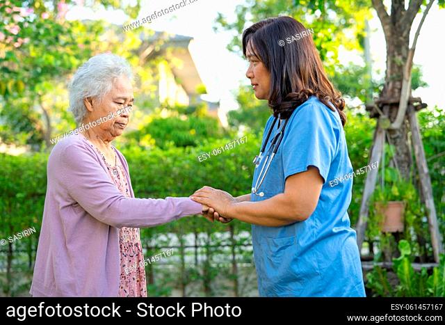 Doctor help and care Asian senior or elderly old lady woman use walker with strong health while walking at park in happy fresh holiday