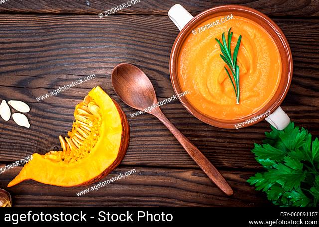 fresh pumpkin soup in a ceramic plate, top view