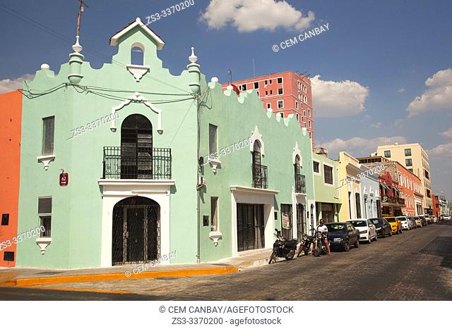 Motorcyclist in front of the colorful colonial buildings in the city center, Merida, Yucatan Province, Mexico, Central America