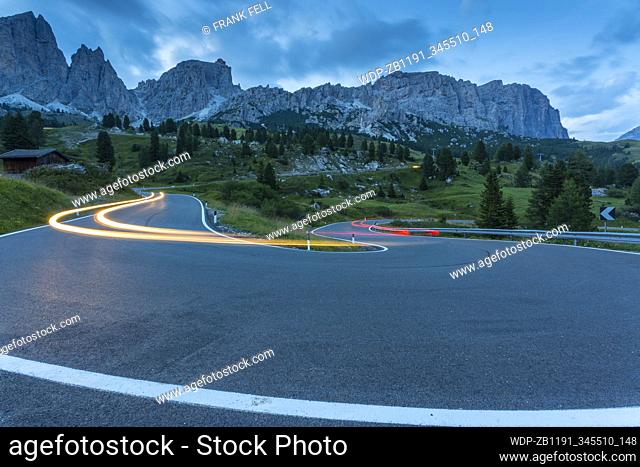 Car trail lights on Passo Pordoi with mountain backdrop at dusk, Province of Bolzano, South Tyrol, Italian Dolomites, Italy, Europe